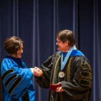 Provost Mili shaking hands with faculty member